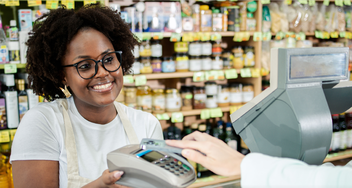 Kenyan shop owner lady smiling confidently using Devachi POS tablet